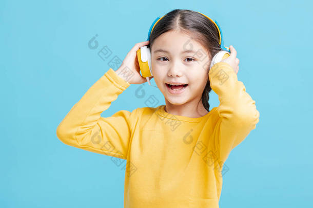 快乐的小女孩在耳机里听音乐
