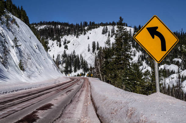 左转弯标志：蒙大拿州的一条雪山路上，人们警告驾车者要<strong>急转弯</strong>.