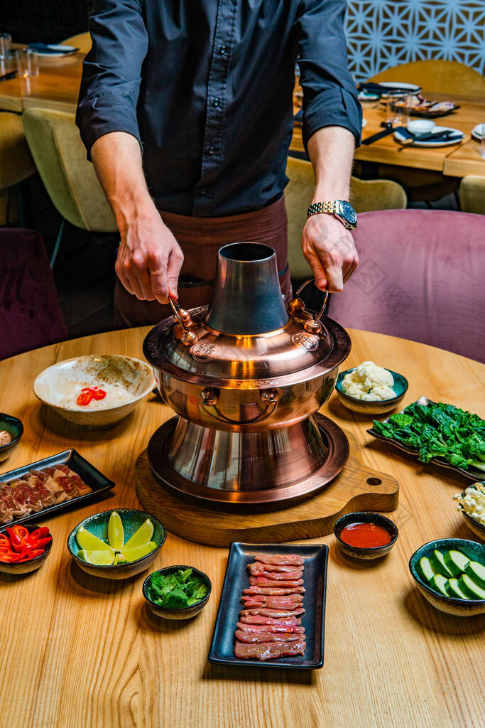 在餐馆里准备传统的亚洲火锅饭的人的剪影代餐