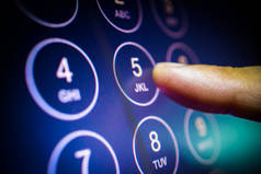 在触摸屏numpad上输入电话号码或密码的手指。通信和安全技术概念