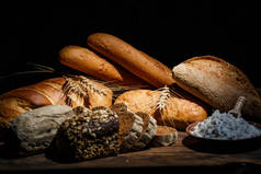 用面粉和无麸质小麦烹调的不同面包放在木制桌子上