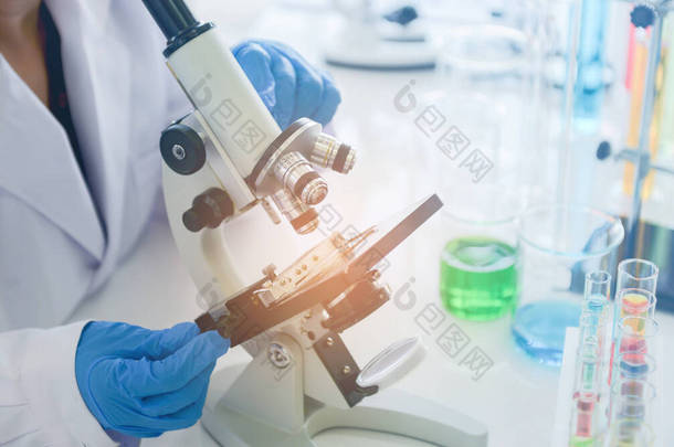 医学研究科学家在化学圈中使用显微镜