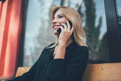 在与朋友积极的智能手机对话中，快乐的白人嬉皮士女孩面带微笑，快乐的女人用4g漫游网络连接通过手机应用程序打电话