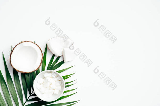 椰子果与一半，烤椰子碗，热带棕榈叶白色背景。平躺在地上，尽收眼底。夏季背景.