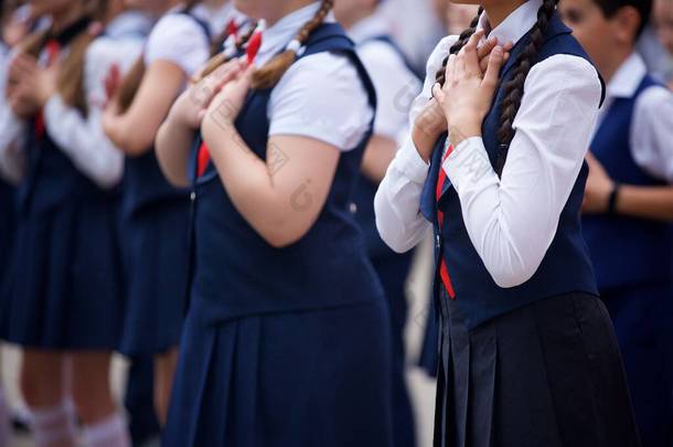 一群身穿漂亮蓝色校服的身份不明的小女孩站在一个庄严的仪式上宣誓要负责任地学习