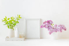 家庭内部装饰元素。白色的框架，花瓶里的丁香枝条，室内装饰