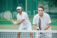 双打队身穿白色运动服的网球队员准备击球