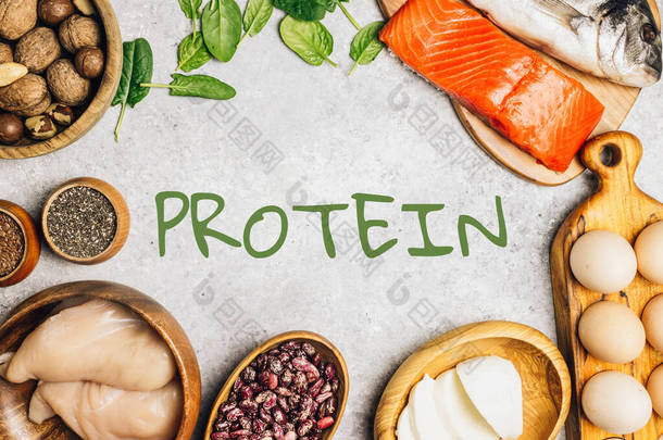 轻质烘焙场的<strong>高蛋白食物</strong>。健康营养或饮食概念。产品为浓密的头发。顶部视图。平躺在床上绿色字体-蛋白质