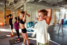 活着。坚强点要健康。男孩热身运动的肖像，和其他孩子一起在体育馆里锻炼。在阳光灿烂的日子里伸展着筋骨。体育、健康生活方式、体育概念