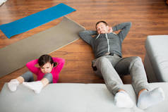父亲和女儿正在家里做腹肌训练。在公寓里锻炼。客厅里的体育培训