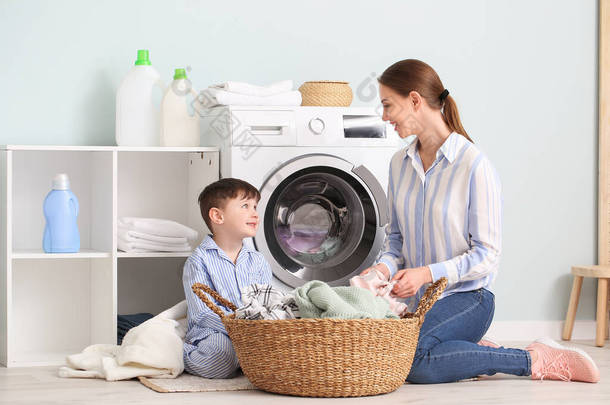 <strong>年轻女</strong>人和她的小儿子在家里洗衣服