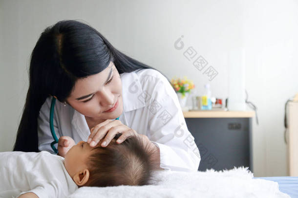 女医生在诊所检查卧床的亚洲小男孩病人。卫生保健概念。复制空间