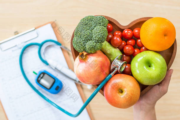 糖尿病监测器、胆固醇饮食和健康食品营养概念，以及营养师心脏菜中的清洁水果和糖尿病测量工具包病人血糖控制记录