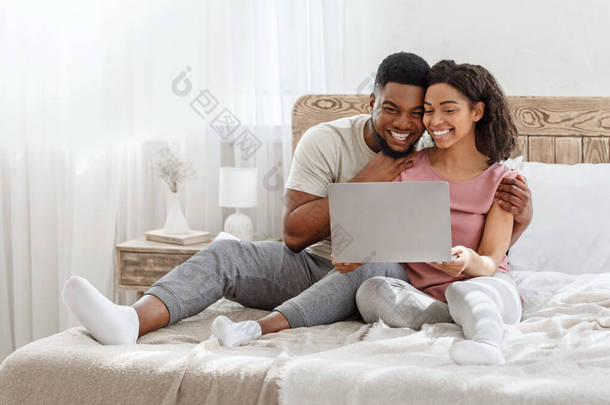 情侣们在卧室看笔记本电脑上的照片