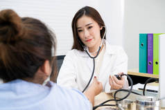 美丽的亚洲医生检查不健康肥胖妇女的血压。保健和福利概念.