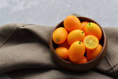 在亚麻布背景的木制碗中,用新鲜的柑橘类水果.健康素食概念。顶部视图.