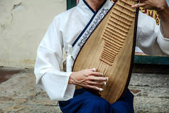 一个男人在演奏一种叫做琵琶的中国乐器