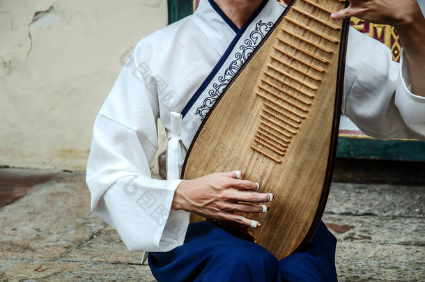 一个男人在演奏一种叫做琵琶的中国乐器