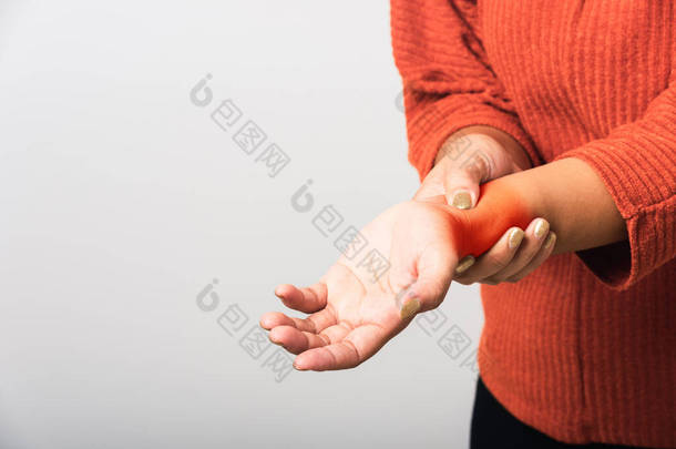 亚洲女人的手紧紧地握住她那双手腕部的剧痛，工作室里的镜头被白色背景隔离，医疗保健药物关节炎身体护理症状办公室综合征的概念
