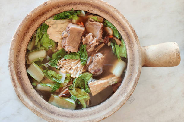 在马来西亚和新加坡，用粘土锅，一种用肉汤烹调的猪肉排骨菜，很受欢迎