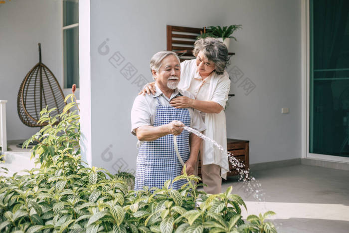 老两口在自家花园浇花