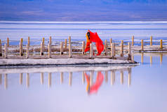 查卡盐湖风景秀丽,蓝天,座落在青海省.那个女孩在查卡盐湖城跳舞