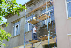 在粉刷混凝土外墙前，脚手架上的建筑承建商须在住宅楼宇的立面贴上石灰、渲染、涂覆、填充物.