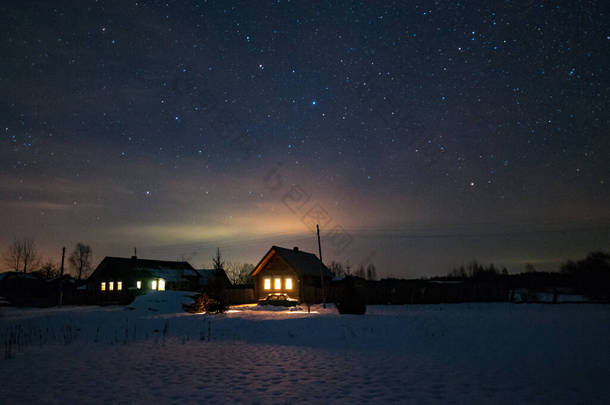 俄罗斯村庄的房子。冬天，寒冷的夜晚。屋顶上的星空.