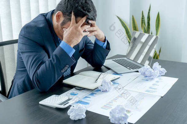 商务人士因商业危机受挫、文书工作堆积如山、文件杂乱无章而表现出疲惫的压力焦虑.