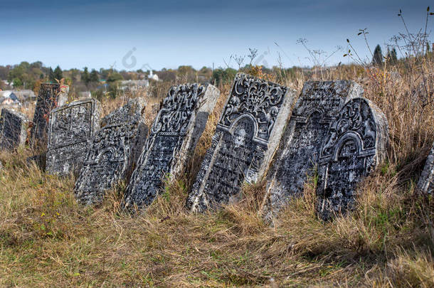 2019年10月12日秋天的老犹太人公墓墓碑在墓地干草的背景上.犹太人公墓是乌克兰萨塔诺夫（Satanov）城型村庄的一个kirkut 。.