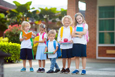 孩子上学去了。开学第一天，男孩和女孩拿着书本和铅笔。小学生们很兴奋回到学校。放假后开始上课。孩子们在学校院子里吃苹果