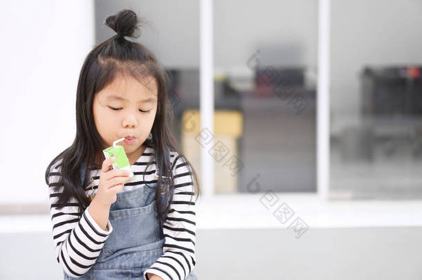 在幼儿园或学校，可爱的亚洲孩子或小女孩喜欢用管子或稻草喝盒装<strong>牛奶</strong>或凝乳和<strong>豆浆</strong>饮料，以获取蛋白质，再到口渴的水中享用美味的甜点和健康的食物