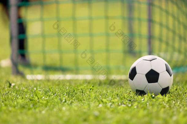<strong>足球场</strong>草地上的足球。足球进球和守门员在一个模糊的背景下