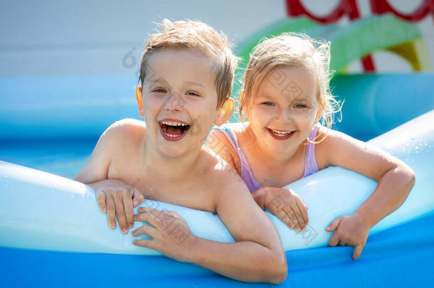 快乐的男孩和女孩正在夏园的游<strong>泳池里玩耍</strong>