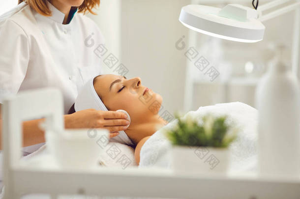 美容院的美容师用棉垫洗脸