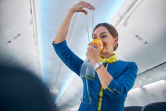 空姐在飞机上展示如何使用氧气面罩