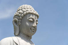 位于越南丹阳的佛寺和蓝天背景的佛头大理石雕像的细节。关闭，复制空间