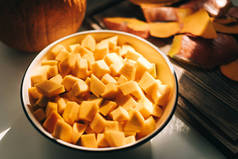 近景新鲜的，生动的橙色南瓜块在一个白色的盘子里。健康和有营养的食物。高质量的照片