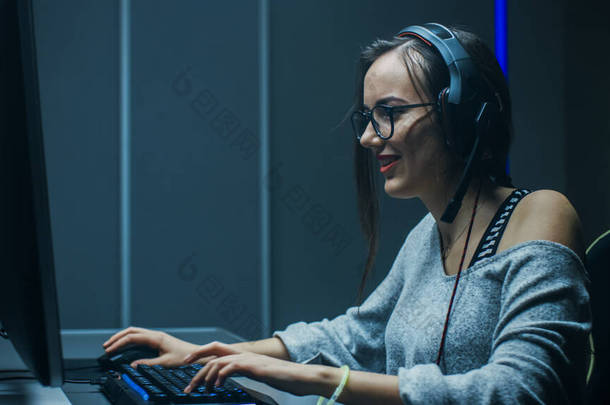 美丽的<strong>职业</strong>游戏女孩在她的<strong>个人</strong>电脑上玩第一人称射击在线视频游戏。临时可爱的极客女孩头戴耳机。在地下游戏俱乐部.