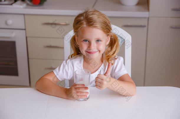 微笑的金发小女孩<strong>喝牛奶</strong>，在厨房里大显身手 