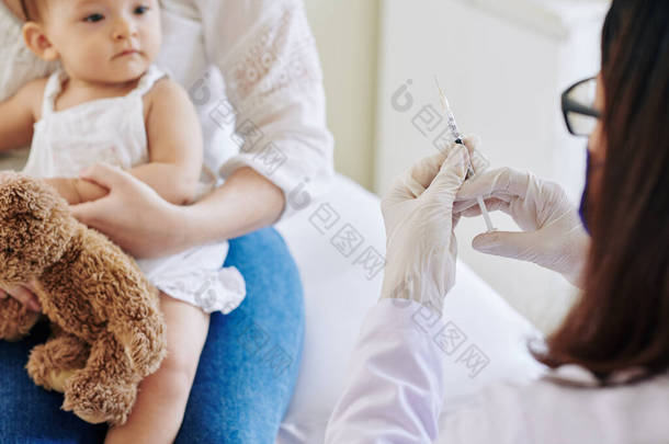 医生准备用<strong>胳膊</strong>向小女孩注射疫苗