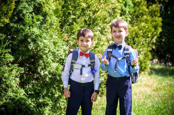 快乐的孩子们回到学校。小学生带着背包到户外学习.孩子们走在一起。开始上课。秋天的第一天。3.小学生时代的男孩和他哥哥.
