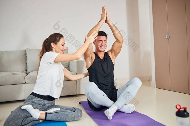 肌肉发达的年轻人试图在一些<strong>指导</strong>下做瑜伽