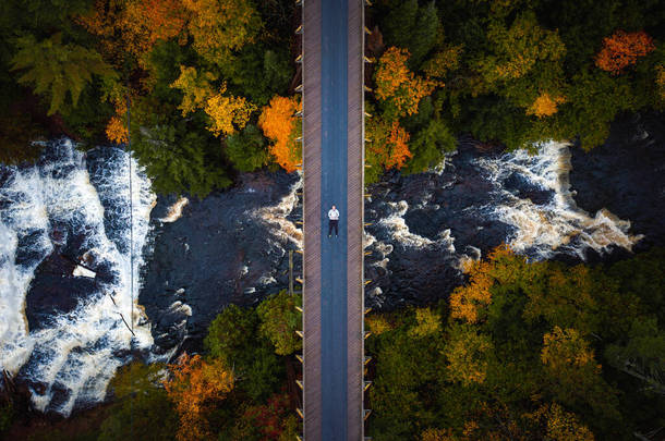 美丽的秋天从空中俯瞰着一个人躺在废弃的铁路桥上，穿过翁托纳贡河，俯瞰着<strong>森林</strong>下美丽的阿盖特<strong>瀑布</strong>.