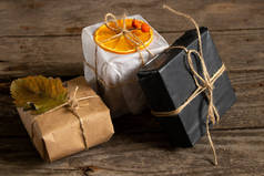 圣诞礼品盒，用纸线和木制背景的手工圣诞装饰品制成，礼品盒