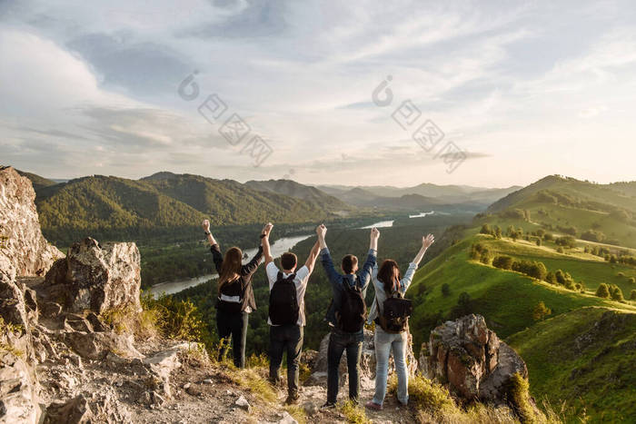 一群四人带着背包在山上徒步旅行。与朋友的旅行和旅行概念