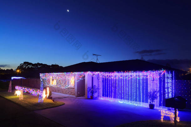 <strong>一座</strong>郊区的房子和车库，装饰着五彩缤纷的圣诞彩灯