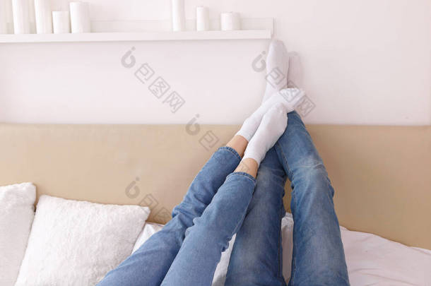 穿白袜的脚踩在房子的床上