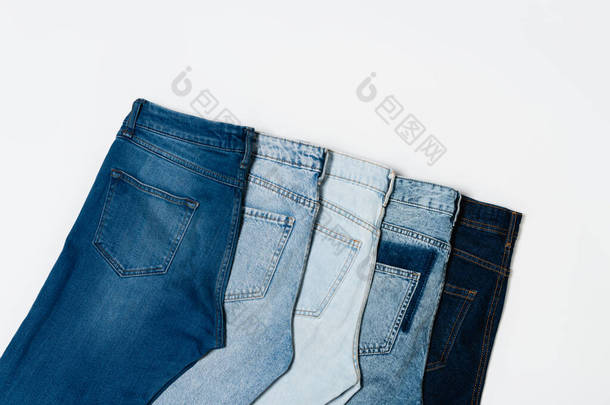 平铺,不同的蓝色牛仔裤,白色背景,顶视图