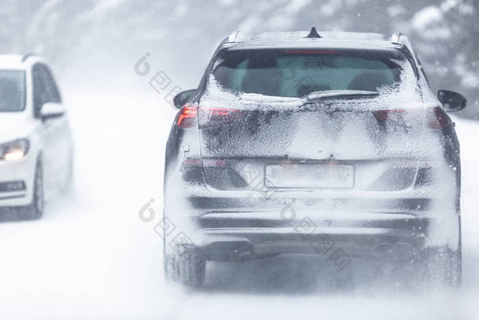 越野车在森林里雪地滑的路上行驶，由于下雪，车牌号难以辨认.